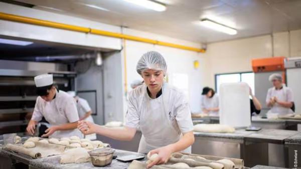 Apprentie boulangère préparant du pain